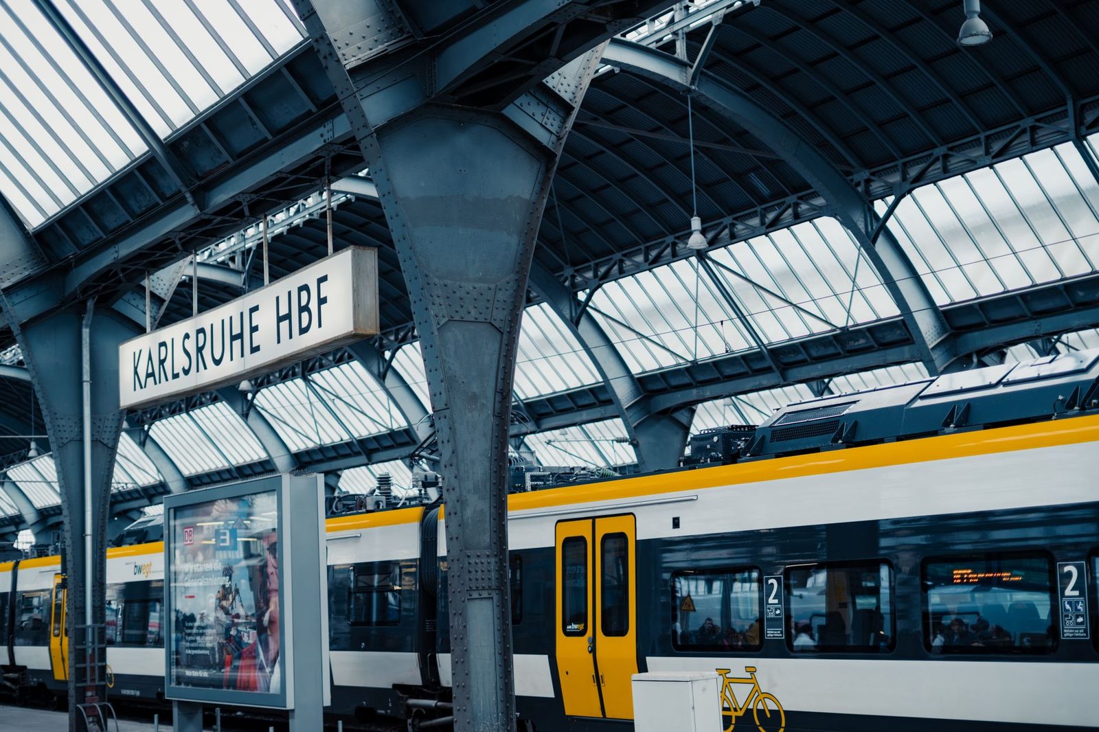 Yellow and white regional train at the platform under the roof of Karlsruhe main station