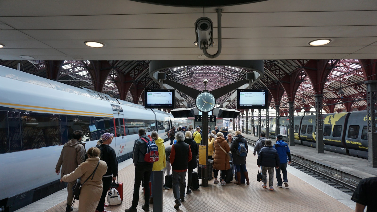 Reisende unter dem gewölbten Dach des Kopenhagener Hauptbahnhofs, eines Halts nahe der Route des neuen Nachtzugs