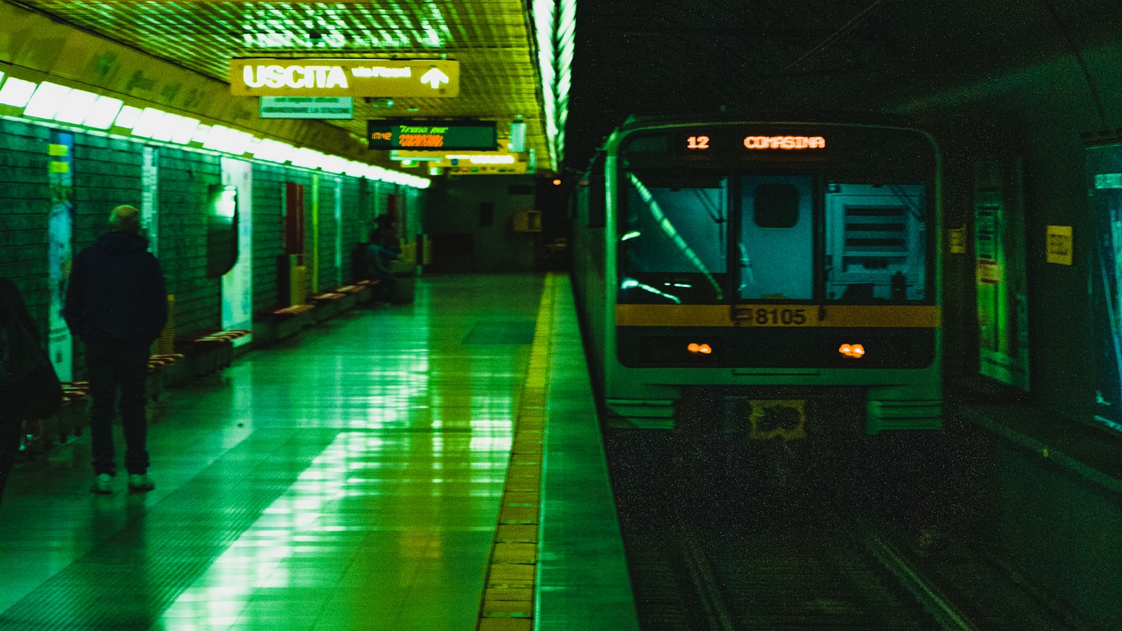 Un quai de métro de nuit à Milan, en Italie, avec une rame qui arrive