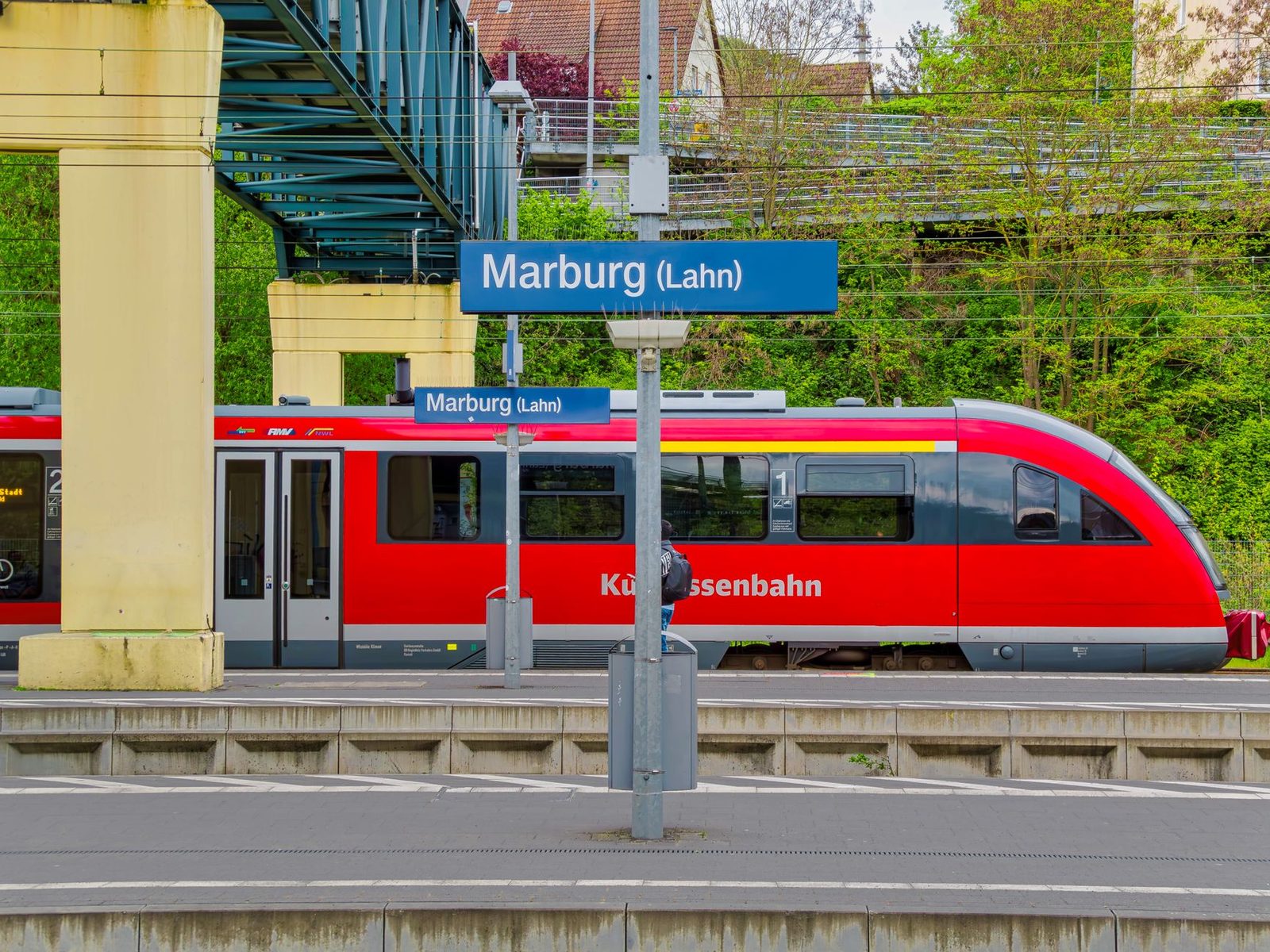 Train régional rouge à quai devant le panneau de la gare de Marburg (Lahn), en Allemagne