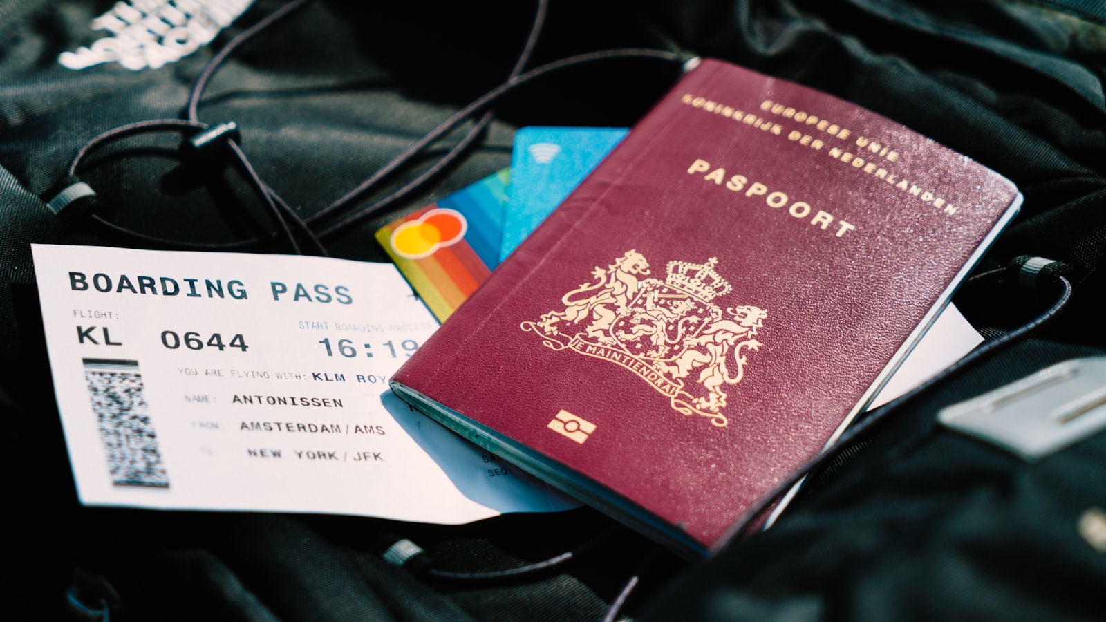 Un passeport bordeaux de l'Union européenne des Pays-Bas posé sur une carte d'embarquement KLM d'Amsterdam