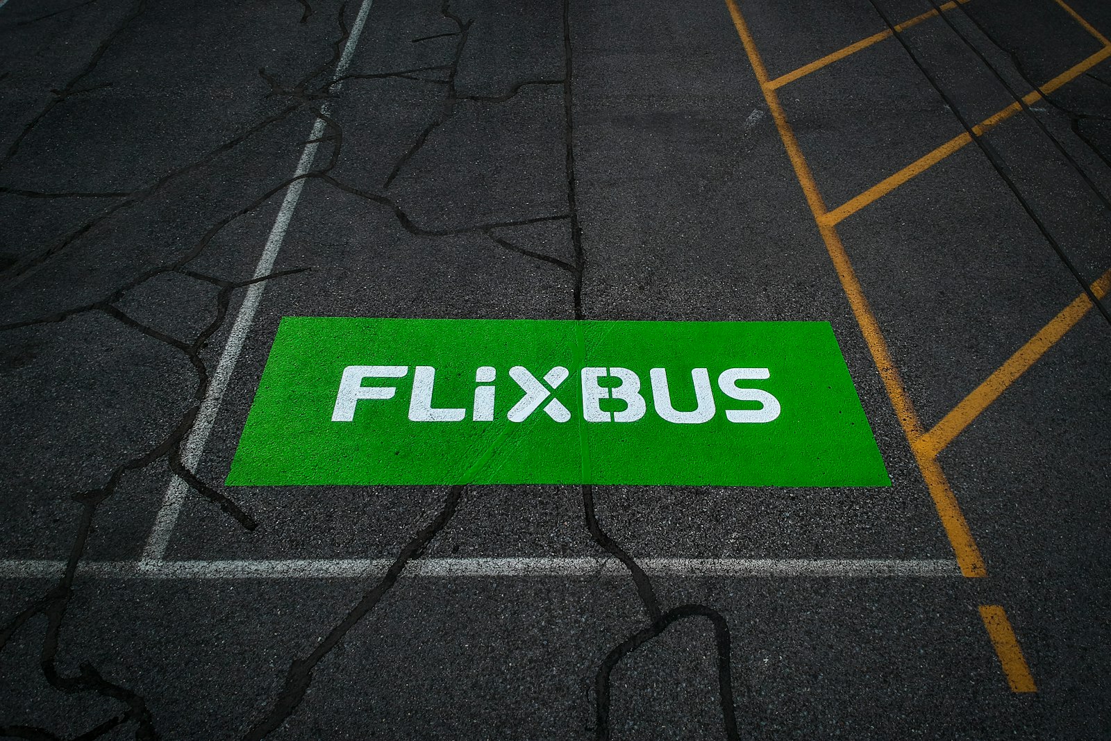 Logo vert FlixBus peint sur un emplacement de stationnement de bus