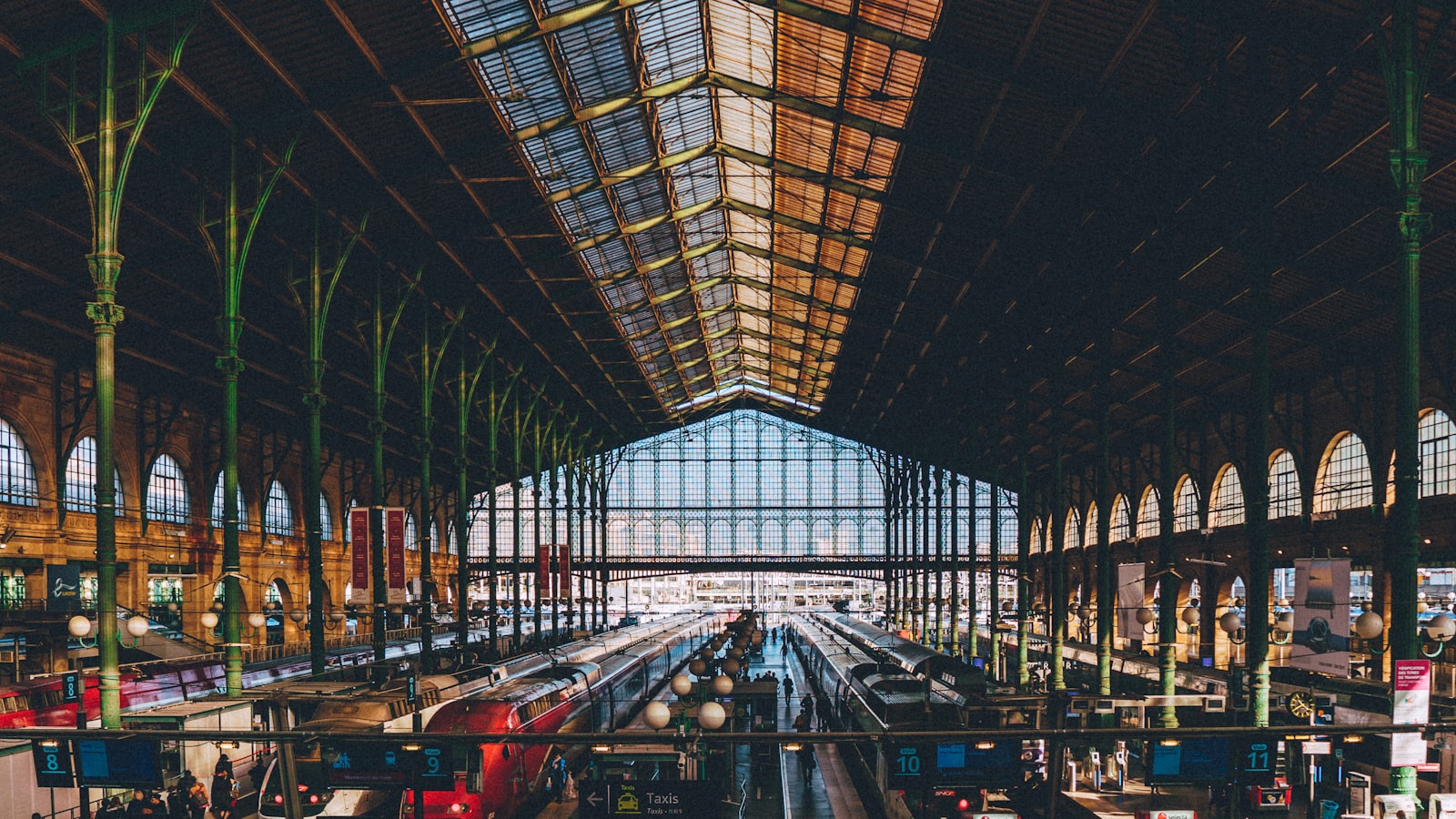 صالة باريس-Gare du Nord المقببة المصنوعة من الزجاج والحديد مع قطارات على الأرصفة