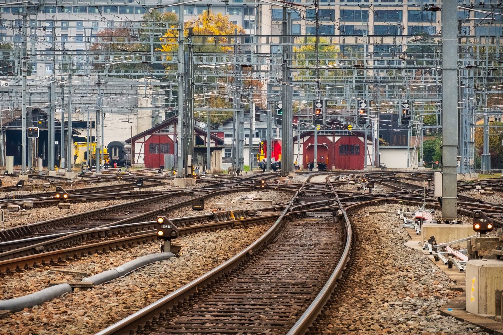 A fan of railway tracks with switches, signals and overhead lines at the approach to a station