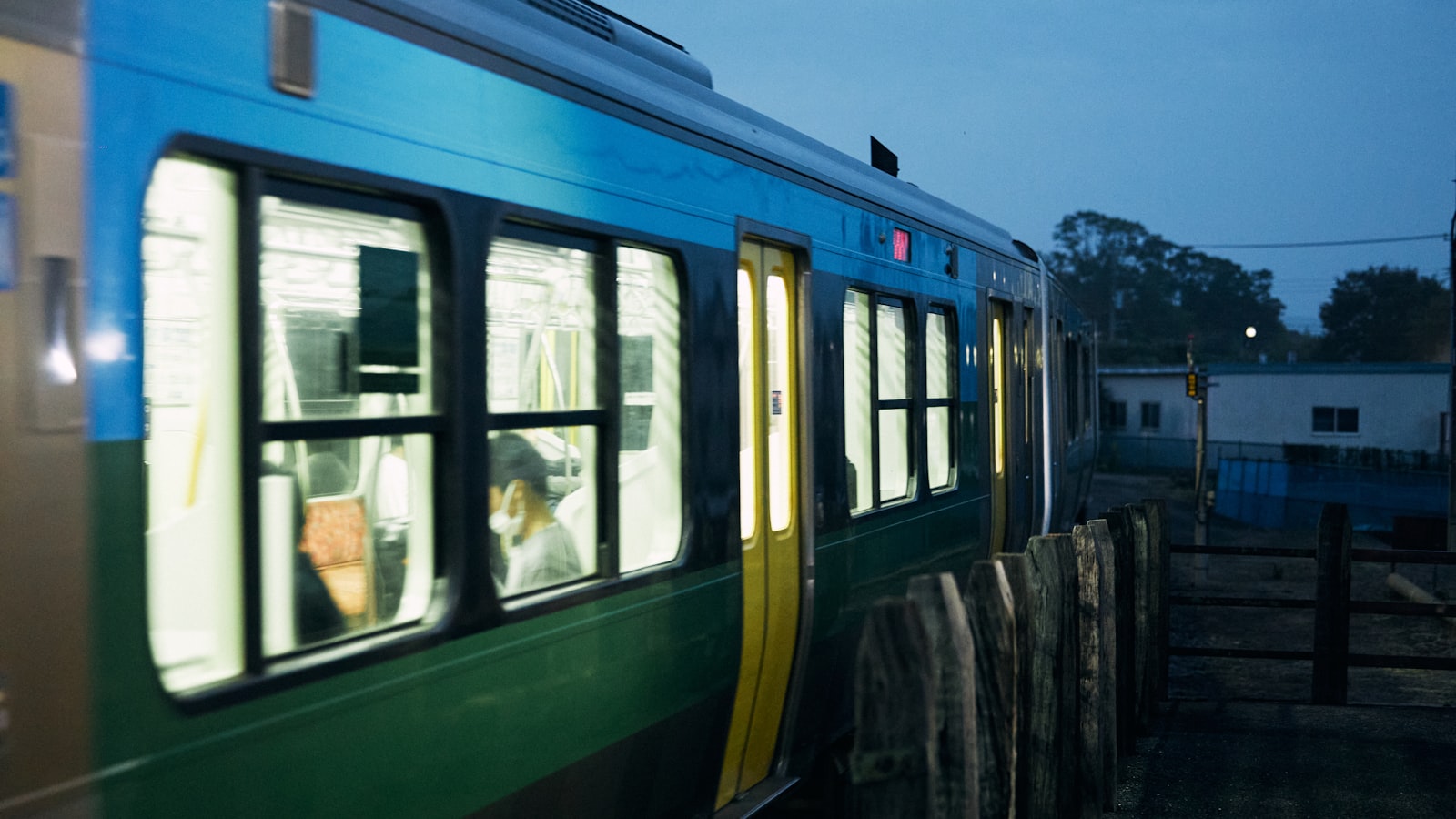 Train de nuit illuminé au crépuscule, les voyageurs s'installent