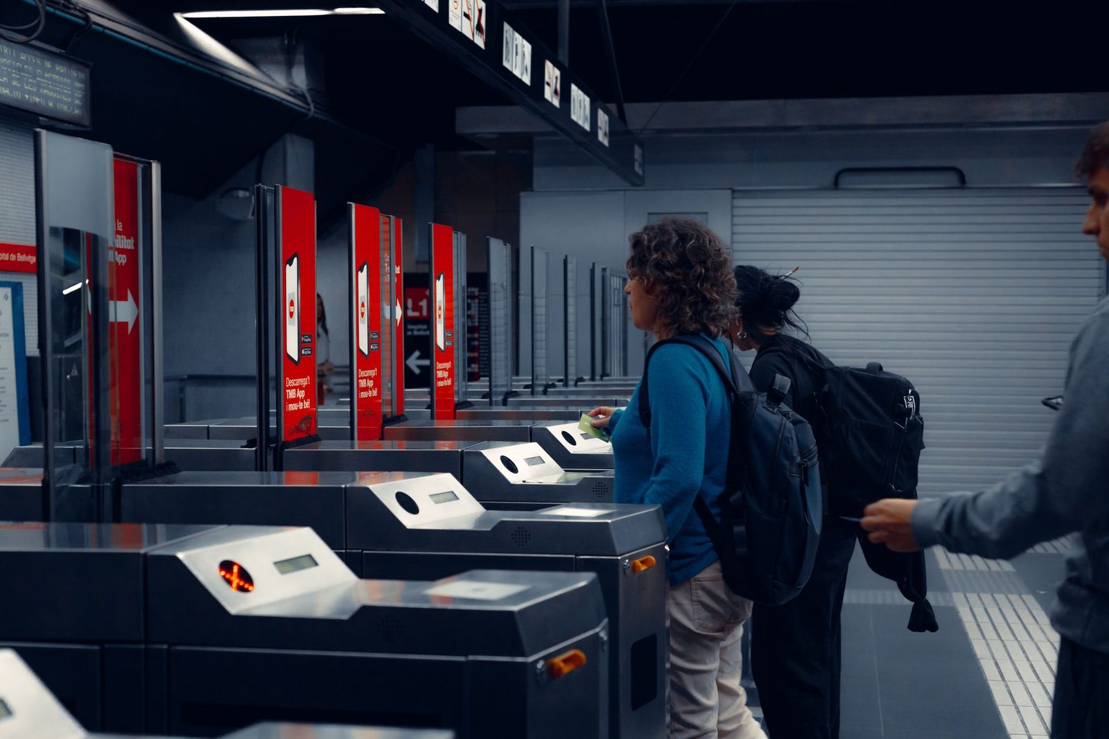 Travellers with backpacks passing through ticket barriers in a metro station