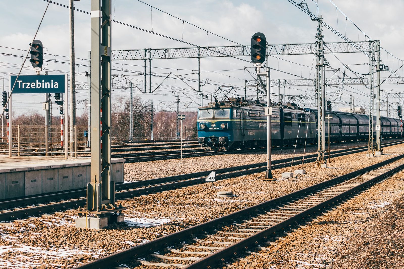 Locomotora eléctrica con tren de mercancías en la estación de Trzebinia, vías, catenarias y señales